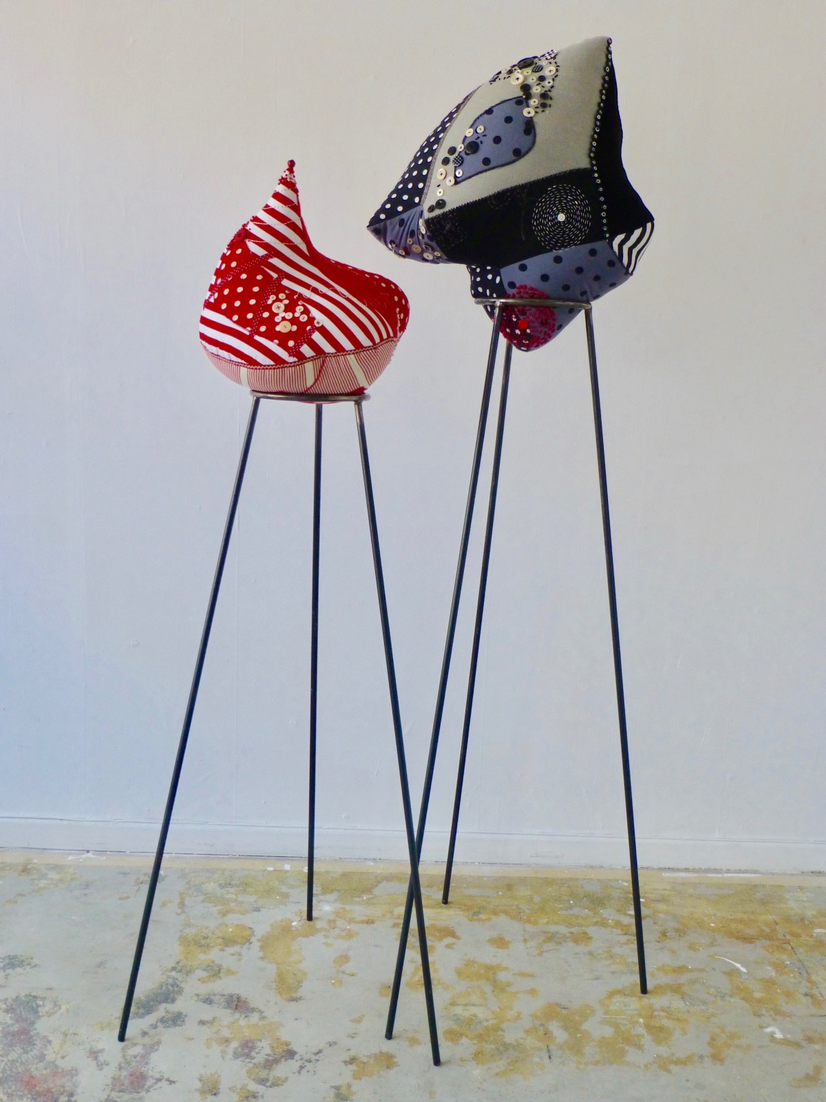 Red and White Fetish, Grey and Black with Red Fetish, both on metal stands